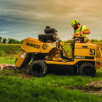 Rayco RG37 wheeled stump grinder in operation with arborist